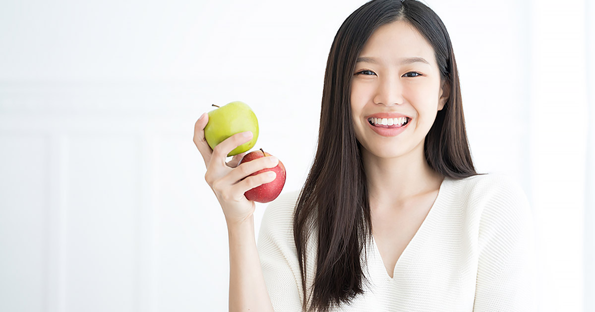 Woman holding 2 apples