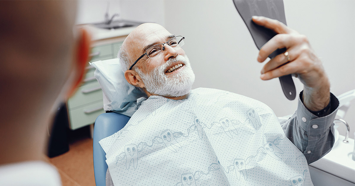 Elderly man at dentist, smiling