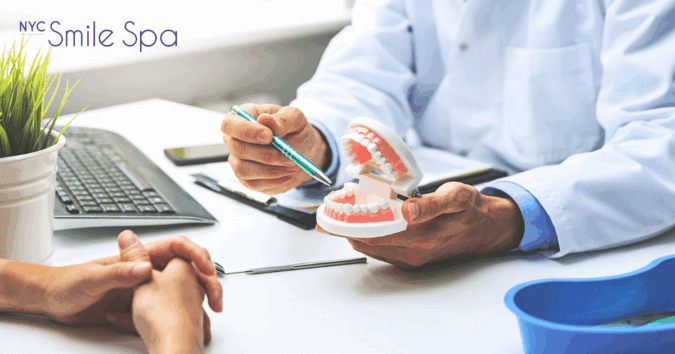 dentist showing fake teeth to patient